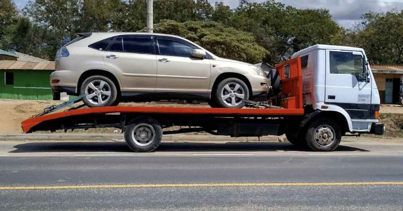 Long-distance towing service loading beige SUV for transport in Norwalk, CT